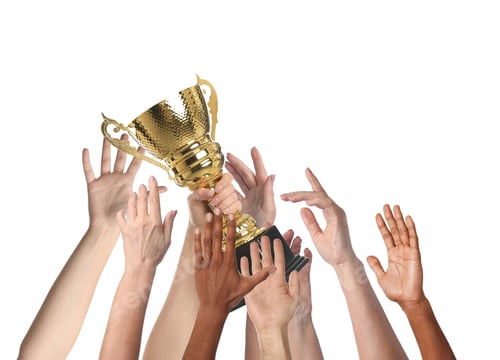 Preview: People reaching for gold cup held by winner against white background, closeup