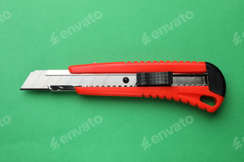 Preview: One sharp paper knife on green background, top view