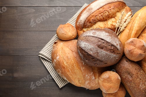 Preview: Different types of bread and spikes on wooden table, top view. Space for text