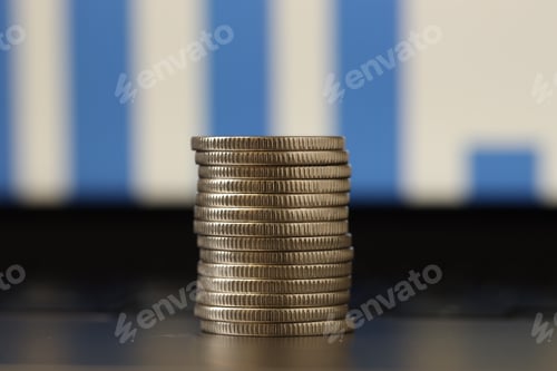Preview: Stack of coins on laptop against blurred background, closeup