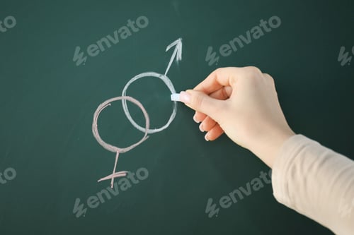 Preview: Sex Education. Woman drawing gender symbols on green chalkboard, closeup