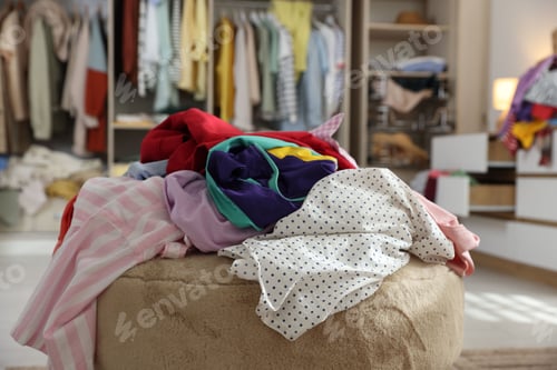 Preview: Many different messy clothes on stool in room, closeup