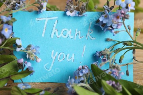 Preview: Card with phrase Thank You and beautiful forget-me-not flowers on table, closeup