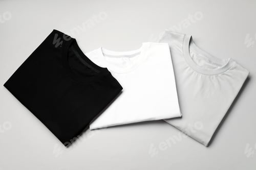 Preview: Blank folded t-shirts on light grey background, top view. Mockup for design
