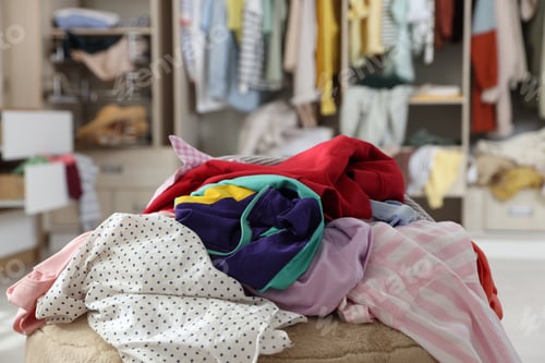 Preview: Many different messy clothes on stool in room, closeup