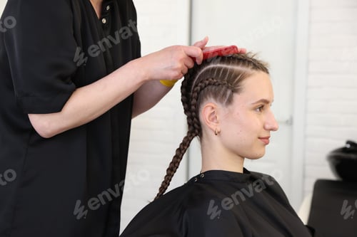 Preview: Hair braiding. Hairdresser working with teenage girl in salon, closeup