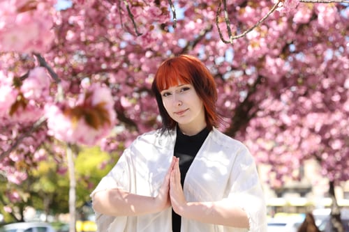 Preview: Beautiful young girl posing near blossoming sakura tree outdoors