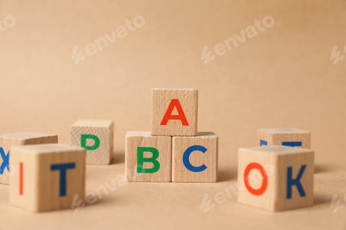Preview: Wooden cubes on beige background, closeup. Children's toy