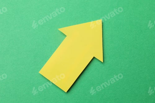 Preview: Yellow paper arrow on green background, top view