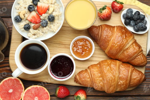 Preview: Healthy breakfast. Tasty croissants, jams, oatmeal with berries, orange juice and coffee on wooden t