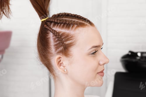 Preview: Teenage girl during hair braiding in salon