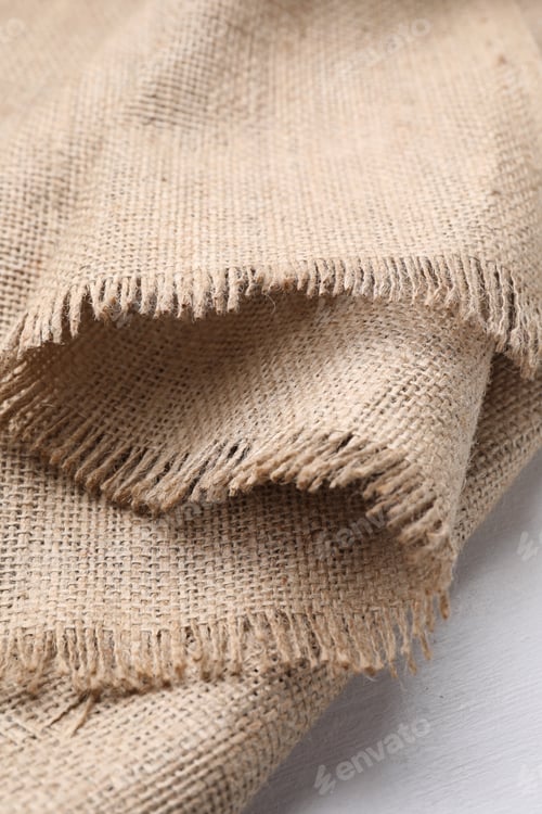 Preview: Natural burlap fabric on white wooden table, closeup