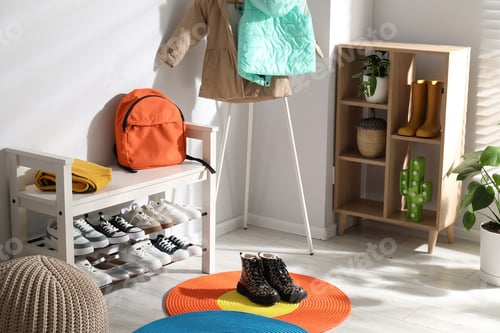 Preview: Shoe storage bench with different children's footwear, backpack and clothes indoors