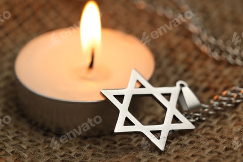 Preview: Holocaust Remembrance Day. Pendant in shape of Star of David and burning candle on burlap cloth, clo