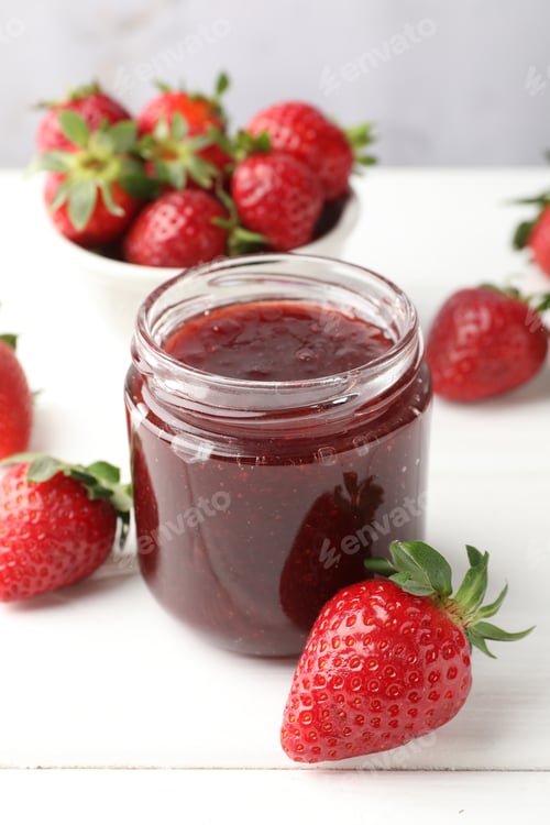 Preview: Yummy strawberry jam in jar and fresh berries on white wooden table, closeup