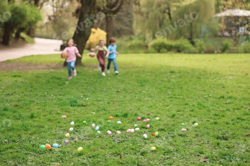 Preview: Easter celebration. Little children hunting eggs outdoors, selective focus
