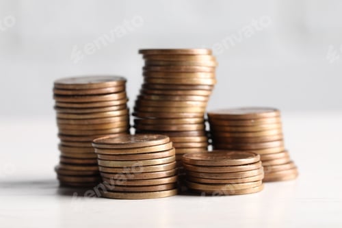 Preview: Stacks of coins on white wooden table, closeup