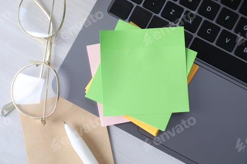 Preview: Reminder. Blank sticky notes, laptop and glasses on white wooden table, flat lay