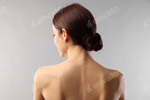 Preview: Beautiful woman with healthy skin on light grey background, back view