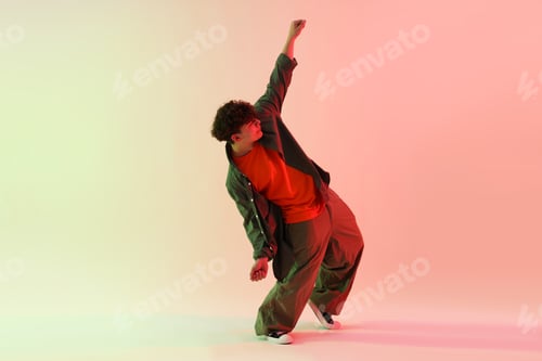Preview: Young man performing hip-hop dance on color background
