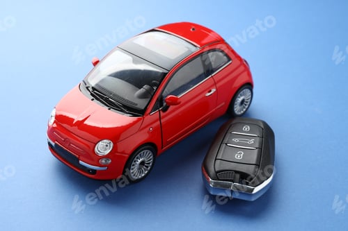 Preview: Buying auto. Key and car model on blue background, closeup