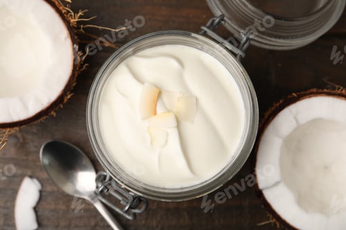 Preview: Delicious coconut yogurt in glass jar and fruits on wooden table, flat lay
