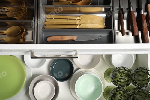 Preview: Ceramic dishware and cutlery in drawers indoors, top view