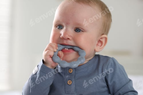 Preview: First baby teeth. Cute child with teether at home