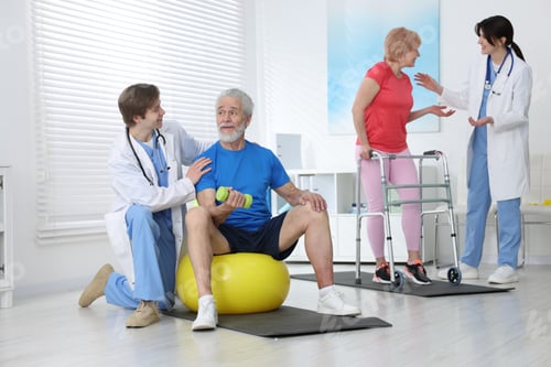 Preview: Senior woman and man exercising under physiotherapists supervision indoors