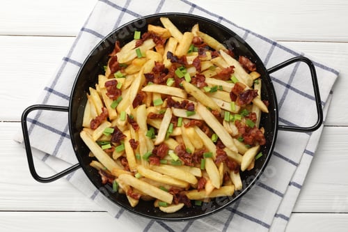 Preview: Delicious French fries with bacon and green onion on white wooden table, top view