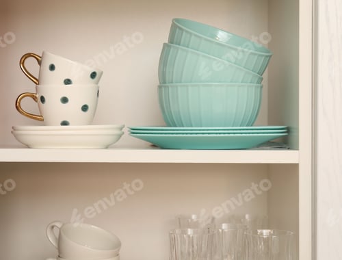 Preview: Cabinet with different clean dishware in kitchen, closeup