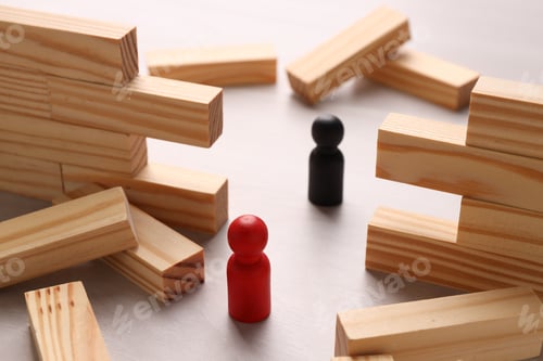 Preview: Collapsed wooden wall made of blocks and human figures on table, closeup. Overcoming obstacles