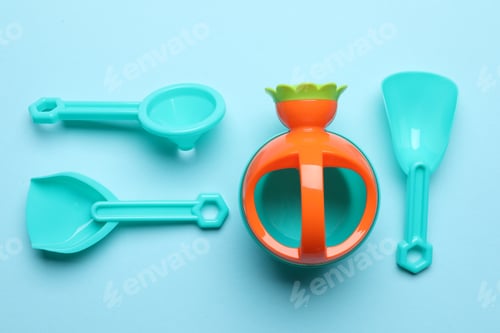 Preview: Bright children's beach toys on light blue background, flat lay