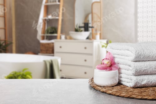 Preview: Fresh towels and cream on table in bathroom. Space for text