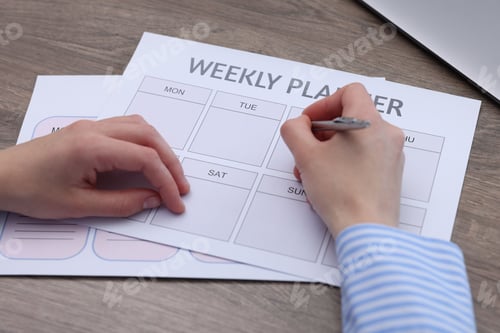 Preview: Woman with weekly planner at wooden desk, closeup