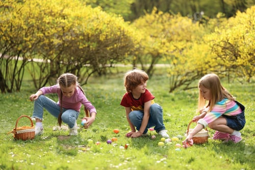 Preview: Easter celebration. Cute little children hunting eggs outdoors