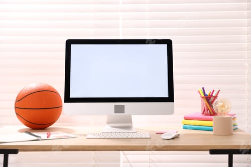 Preview: Stylish workplace with modern computer, lamp, stationery and basketball ball on wooden table indoors