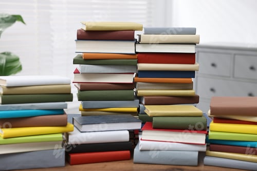 Preview: Stacks of different books on wooden table indoors