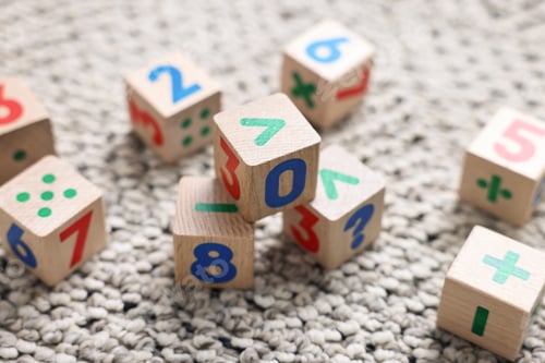 Preview: Wooden cubes with numbers and symbols on floor, closeup
