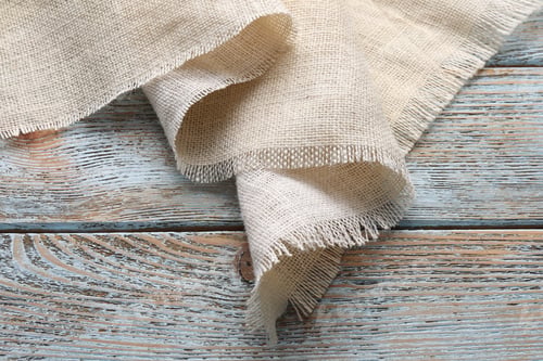 Preview: Natural burlap fabric on wooden table, closeup