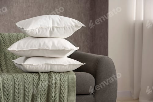 Preview: Stack of soft white pillows on sofa and blanket indoors