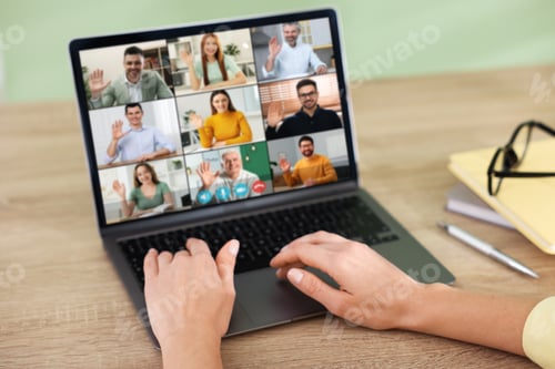 Preview: Woman having video chat with her coworkers via laptop at home, closeup