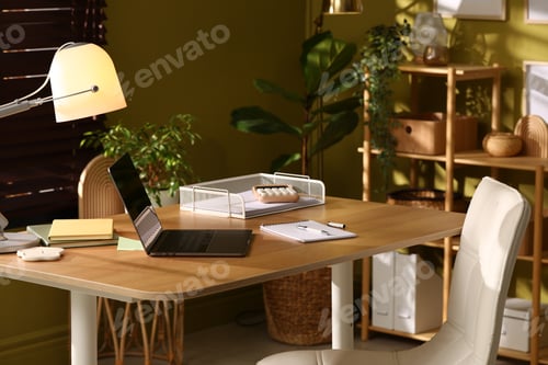 Preview: Stylish workplace with laptop, stationery and lamp on wooden desk indoors, closeup