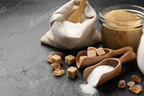 Preview: Different types of sugar on black table, closeup. Space for text