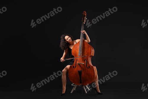 Preview: Woman playing double bass on black background