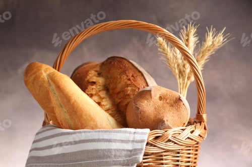 Preview: Different types of bread and spikes in wicker basket on grey background, closeup