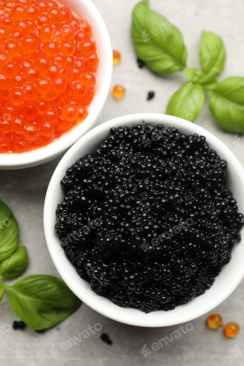 Preview: Delicious red and black caviar with basil on grey table, flat lay