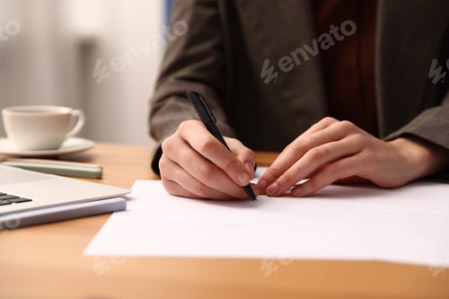 Preview: Woman writing on sheet of paper with pen at table, closeup