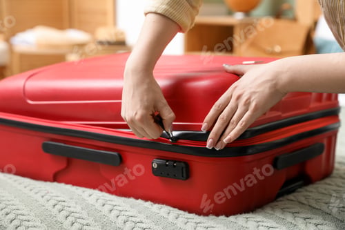 Preview: Woman packing suitcase for trip on bed, closeup