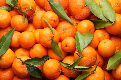 Preview: Many fresh ripe tangerines with green leaves as background, top view